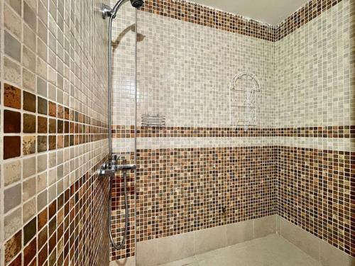 a bathroom with a shower with brown tiles at Magnifique villa - 5 chambres - Ifrane in Ifrane