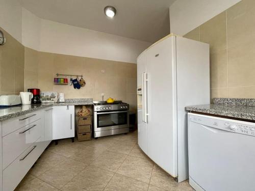a kitchen with white cabinets and a refrigerator at Magnifique villa - 5 chambres - Ifrane in Ifrane
