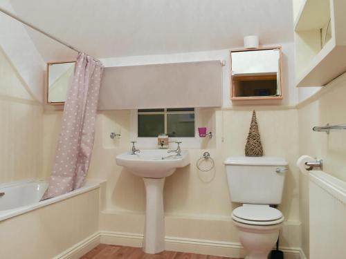 a bathroom with a toilet and a sink at Sweet Pea Cottage in Heacham