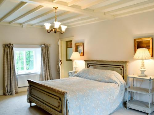 a bedroom with a bed and a chandelier at Riverside Cottage in Washford