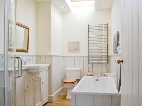 a white bathroom with a sink and a toilet at Riverside Cottage in Washford