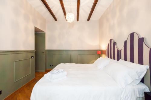 a bedroom with a large white bed and a chandelier at Salotto Monti in Rome