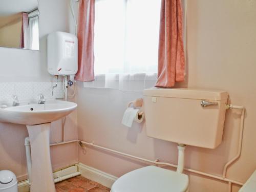 a bathroom with a toilet and a sink at Log Cabin in Lamphey
