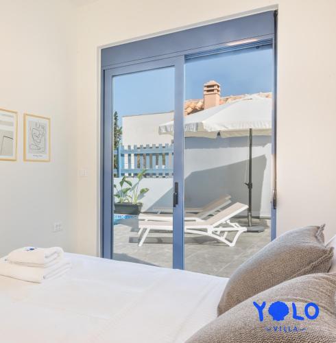 a bedroom with a bed and a view of a patio at Villa YOLO in Almirida