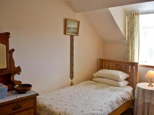 a small bedroom with a bed and a window at Fron Erch Cottages - 2711 in Llanarmon