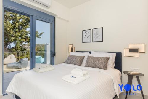a bedroom with a large bed and a large window at Villa YOLO in Almirida