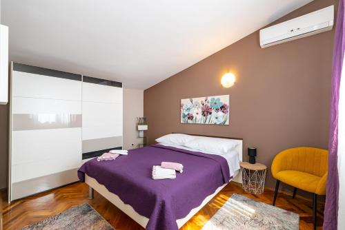 ein Schlafzimmer mit einem lila Bett und einem gelben Stuhl in der Unterkunft Holiday home Mirko in Knin