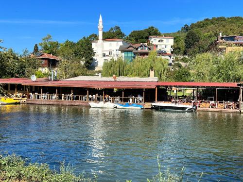 um restaurante num rio com barcos na água em Ağva Kapım Otel em Şile