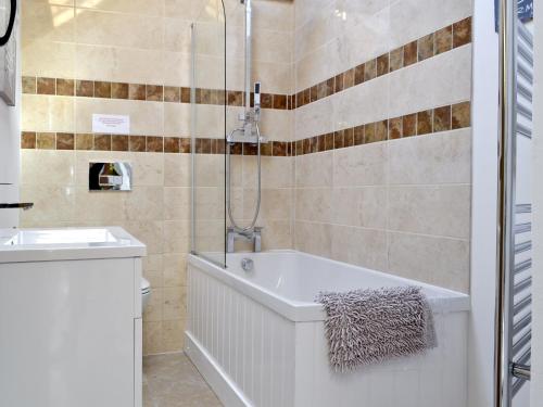 The Parlour في Arlingham: حمام مع حوض استحمام ومغسلة