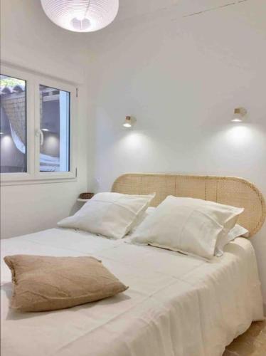 - un lit blanc avec des oreillers blancs et une fenêtre dans l'établissement Appart Bianca T2 - Terrasse - Parking - Calme - 1mn de la mer, à Cassis