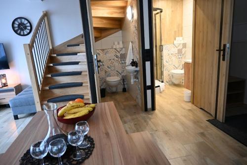 a room with a table with wine glasses and a staircase at Willa i domki Victoria in Wisła