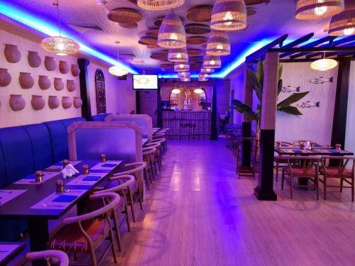 a dining room with tables and chairs and purple lights at FORTUNE ATRIUM HOTEL in Dubai