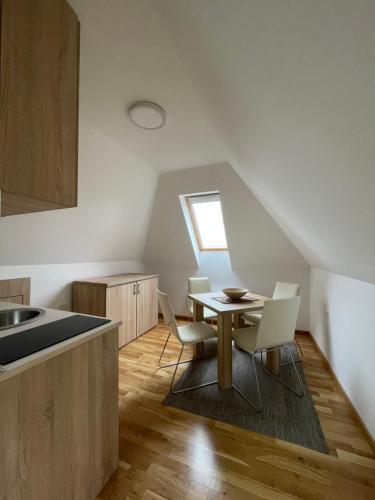 a kitchen with a table and chairs in a room at Alexandro Apartmani Zlatibor in Zlatibor