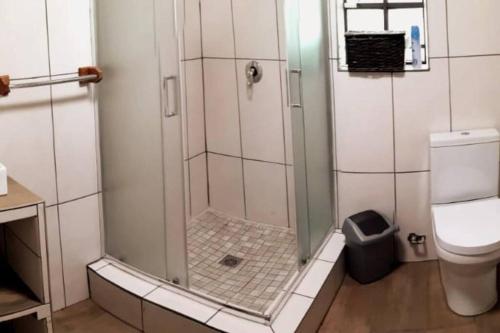 een badkamer met een douche en een toilet bij Amani Milele (Everlasting Peace) in Marloth Park