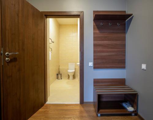 a bathroom with a toilet and a wooden door at Готель Динамо in Lviv