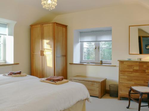 GoodrichにあるWren Cottageのベッドルーム1室(ベッド2台、ドレッサー、窓付)