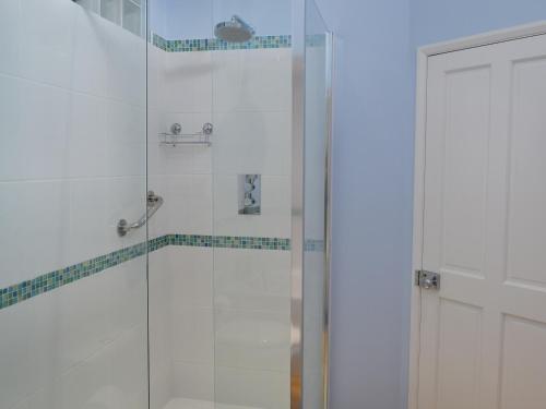 a bathroom with a shower with a glass door at Buckingham Cottage in Ventnor