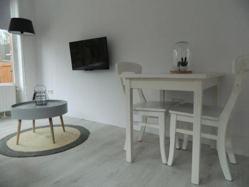 a dining room with a table and a table and chairs at Modern en sfeervol appartement aan zee met airco in Zoutelande