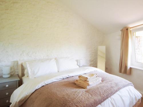 a bedroom with a bed with towels on it at Dandelion Cottage - 28151 in Totnes