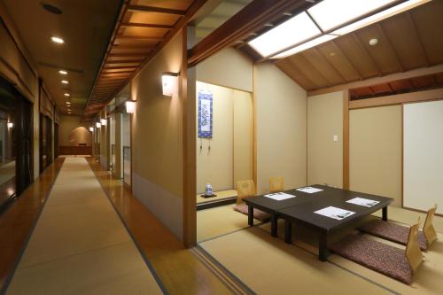 a dining room with a table and chairs in a hallway at Kami no yama Azumaya in Kaminoyama