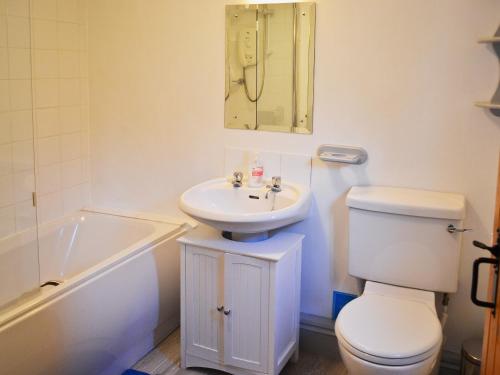 y baño con lavabo, aseo y bañera. en Thatch Cottage, en Saint Hilary