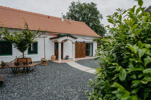 una pequeña casa blanca con techo rojo en Landhaus Schaller im Südburgenland, en Maria Bild