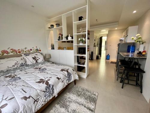sypialnia z łóżkiem i biurkiem oraz kuchnia w obiekcie Elaiza's Cozy Home - Matina Enclaves Building C Unit 815 w mieście Davao