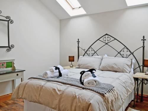 dos animales de peluche en una cama en un dormitorio en The Stables en Forncett Saint Mary