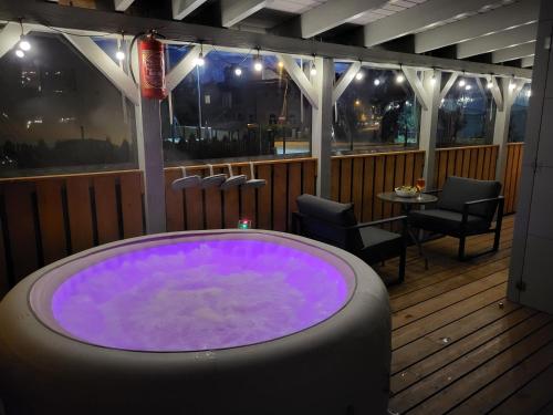 a jacuzzi tub on a deck with a table and chairs at Apartamenty Promyk Wisełka in Wisełka