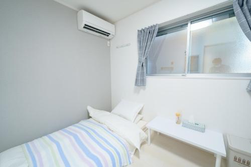 Habitación blanca con cama y ventana en Osaka - House - Vacation STAY 8351, en Osaka