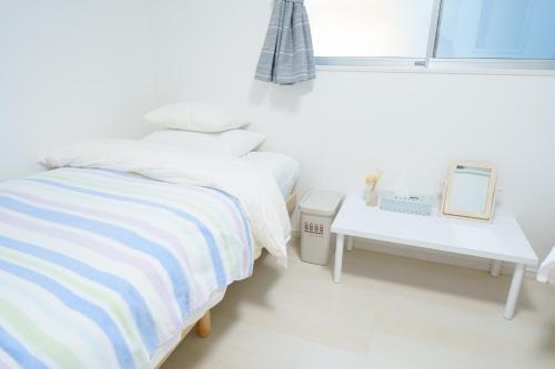 a white bedroom with a bed and a table at Osaka - House - Vacation STAY 8920 in Osaka