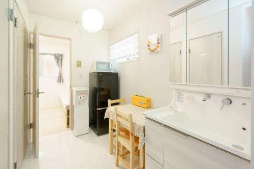 a kitchen with a table and a black refrigerator at Osaka - House - Vacation STAY 8920 in Osaka