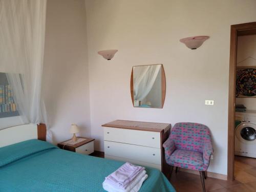 a bedroom with a bed and a mirror and a chair at Il Nido di Mortelle II in Messina