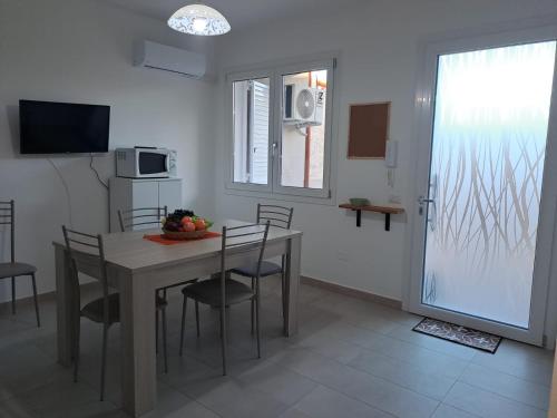 a kitchen and dining room with a table and chairs at Casa Istadi in Maracalagonis