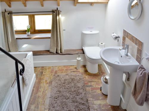 a bathroom with a sink and a toilet and a tub at The Chaff House in Arlingham