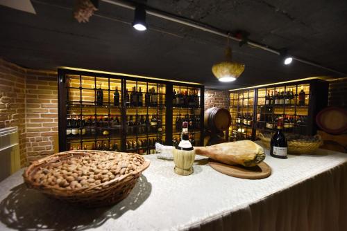 a table with a basket of food and bottles of wine at Hotel Hymeti's Palace in Pogradec