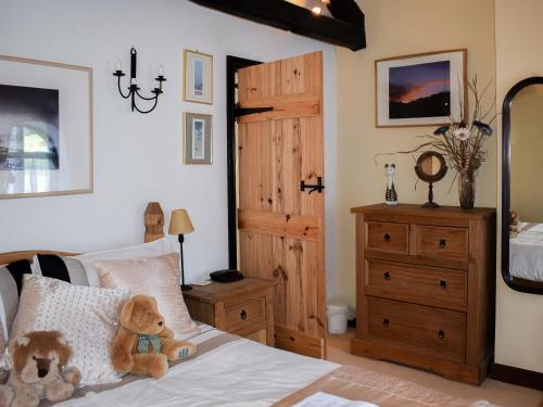 a teddy bear sitting on a bed in a bedroom at River View Cottage in Staveley