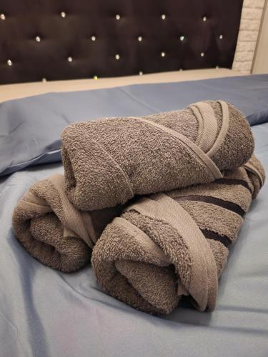 uma pilha de toalhas sentadas em cima de uma cama em Apartament P&P Prestige II em Inowrocław