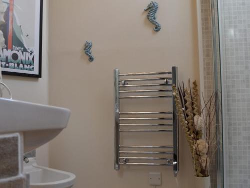 La salle de bains est pourvue d'un sèche-serviettes et d'un lavabo. dans l'établissement River View Cottage, à Staveley