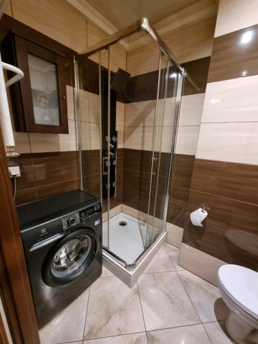 a bathroom with a washing machine and a toilet at Apartament P&P Prestige II in Inowrocław