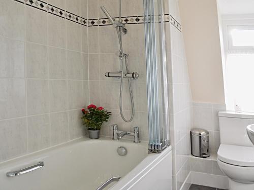 a bathroom with a bath tub and a toilet at 5 Coast Lodge in Pevensey