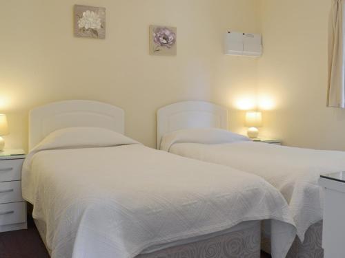 2 camas en un dormitorio con sábanas blancas en The Cottage - B4014 en Wendling