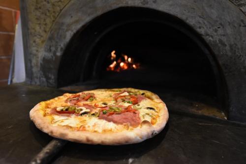 a pizza is being cooked in a pizza oven at Hotel Hymeti's Palace in Pogradec