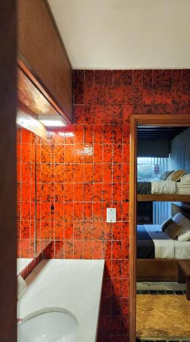a bathroom with red tiled walls and a bath tub at Bucanaan hostel boutique in Córdoba