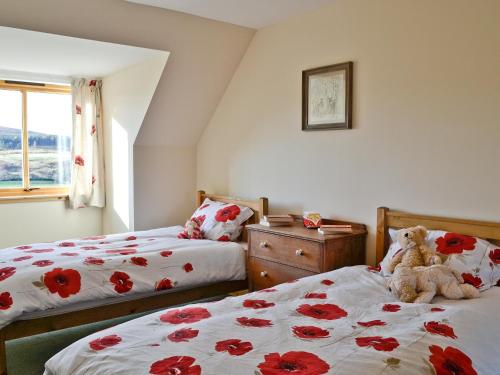 a bedroom with two beds and a teddy bear sitting on the bed at Mountain View in Tomintoul
