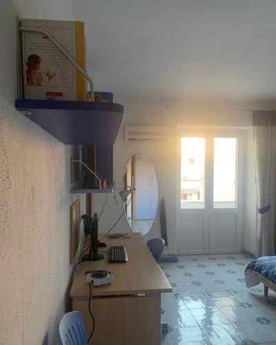 una cucina con bancone e una stanza con porta di La Stanza sul Porto a Ischia