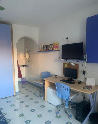 um escritório com uma secretária com um computador e duas cadeiras em La Stanza sul Porto em Ischia