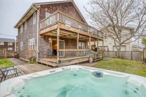 a house with a hot tub in the yard at Slack Tide - Meredith Lodging in Seaside