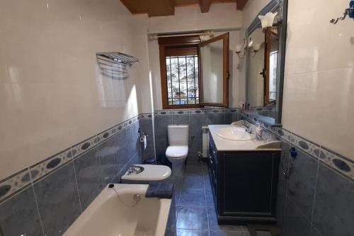 uma casa de banho com 2 lavatórios, uma banheira e um WC. em Casa da Pilar - A Ponte 