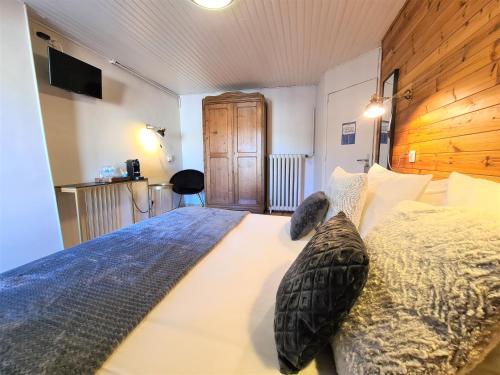um quarto com uma cama grande e uma cabeceira em madeira em Le Grand Hotel em Barcelonnette